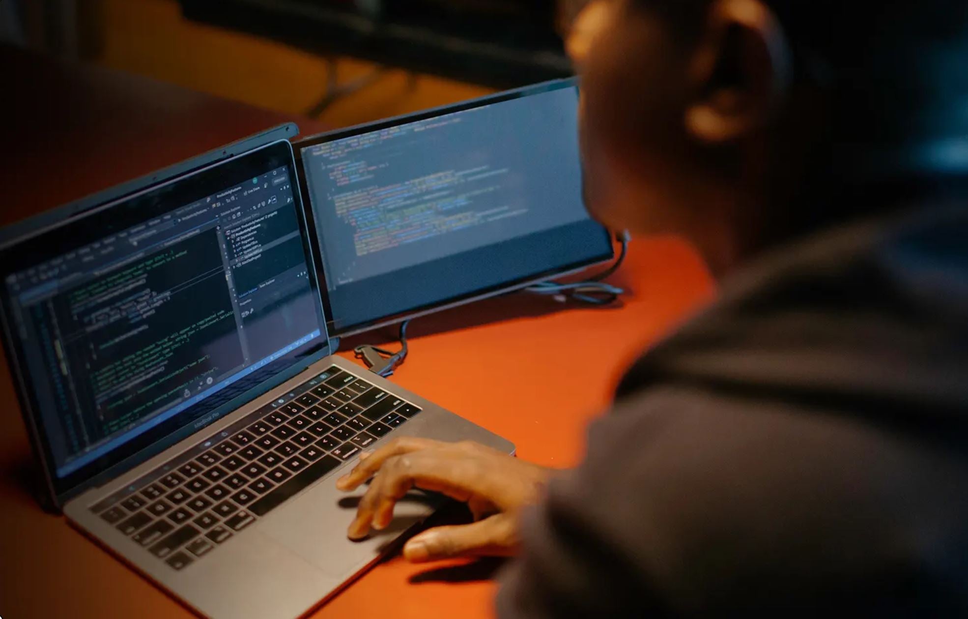 person coding with portable laptop monitor